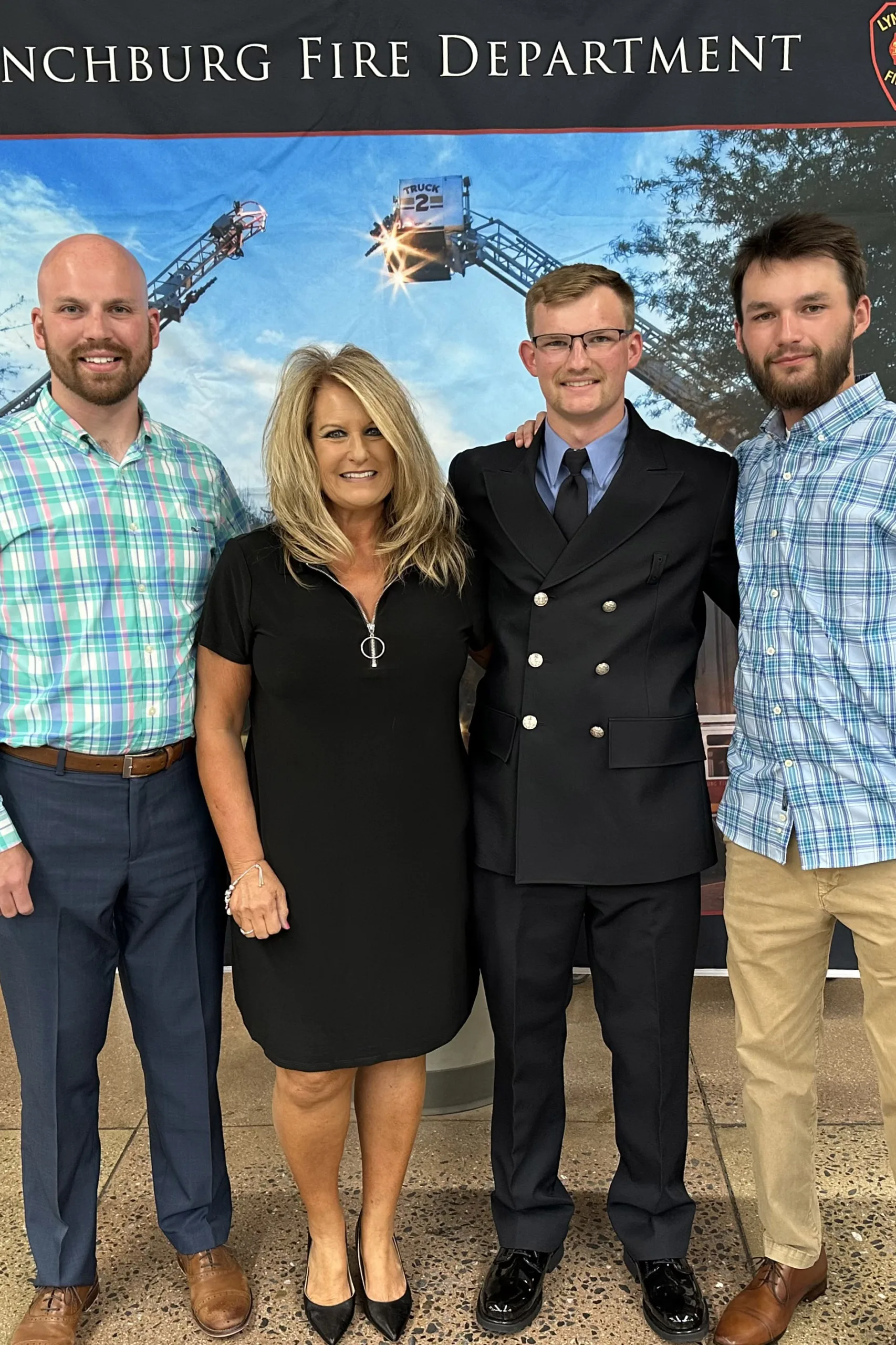 Four people posing in front of a banner for the lincolnburg fire department.